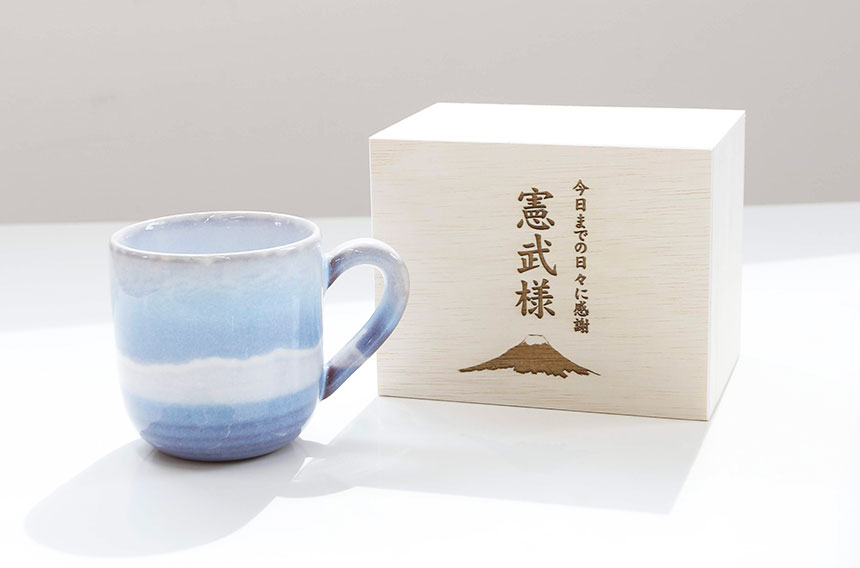 オリジナルデザインを彫刻した木箱に入れた萩焼マグカップの記念品