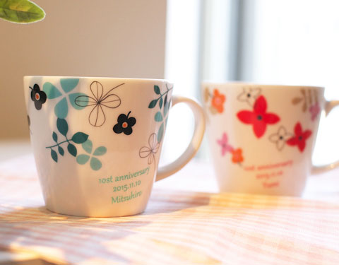 草花模様のデザインでお茶の時間を彩る、名入れペアマグカップ